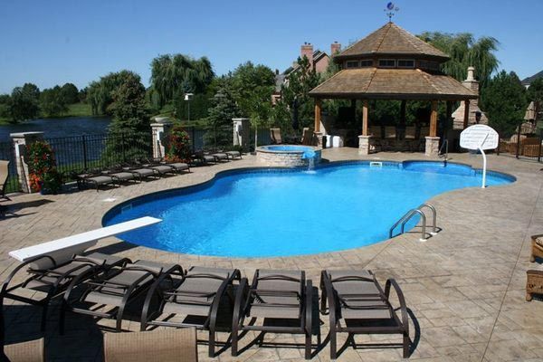 A large swimming pool with a gazebo in the background