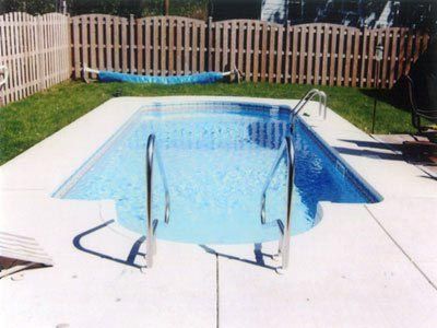 A swimming pool with a fence in the background
