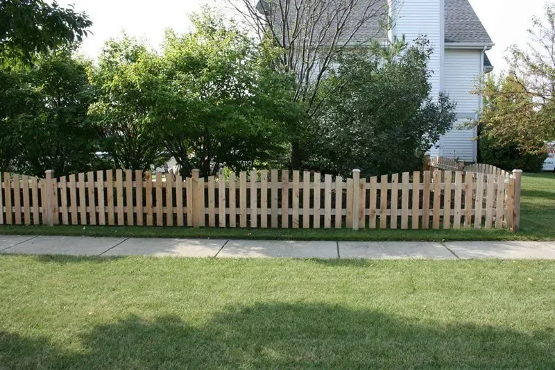 A wooden picket fence in front of a house