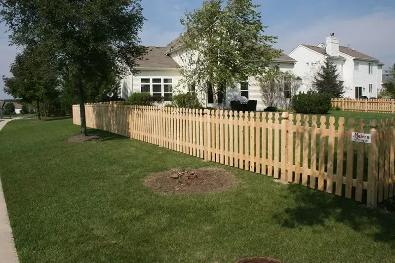 A wooden picket fence in front of a house