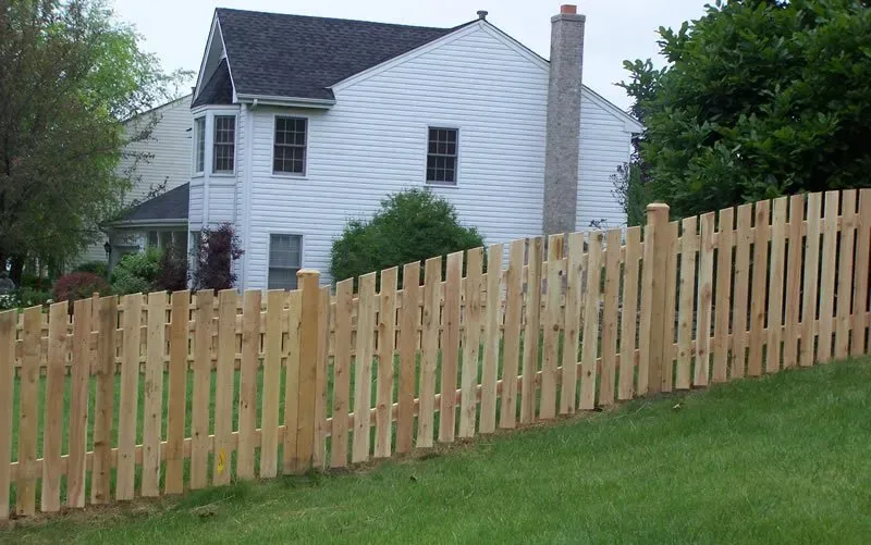 A white house with a wooden fence in front of it