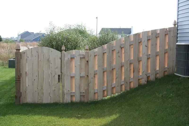 A wooden fence with a gate in the backyard