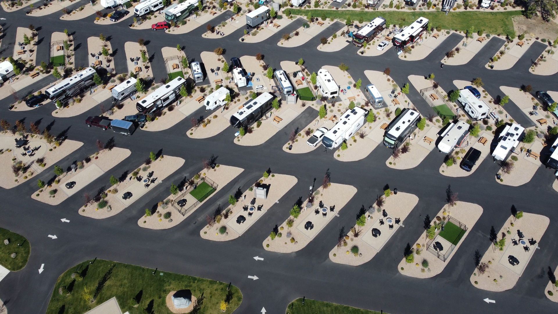 Aerial view of an RV campground with rows of parked motorhomes and trailers on paved sites