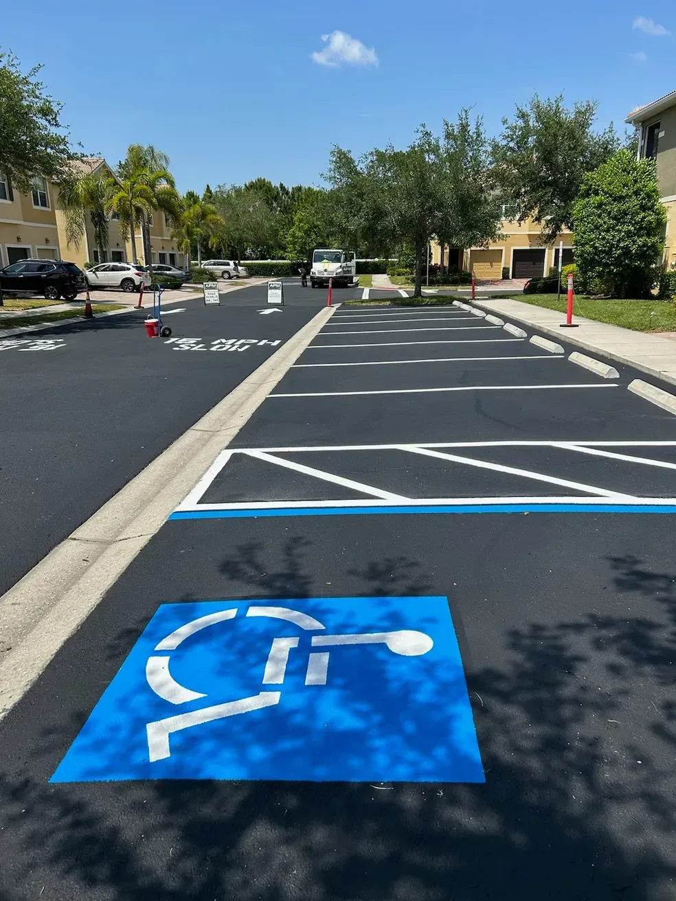 Accessible parking space with blue wheelchair symbol on asphalt near apartment buildings