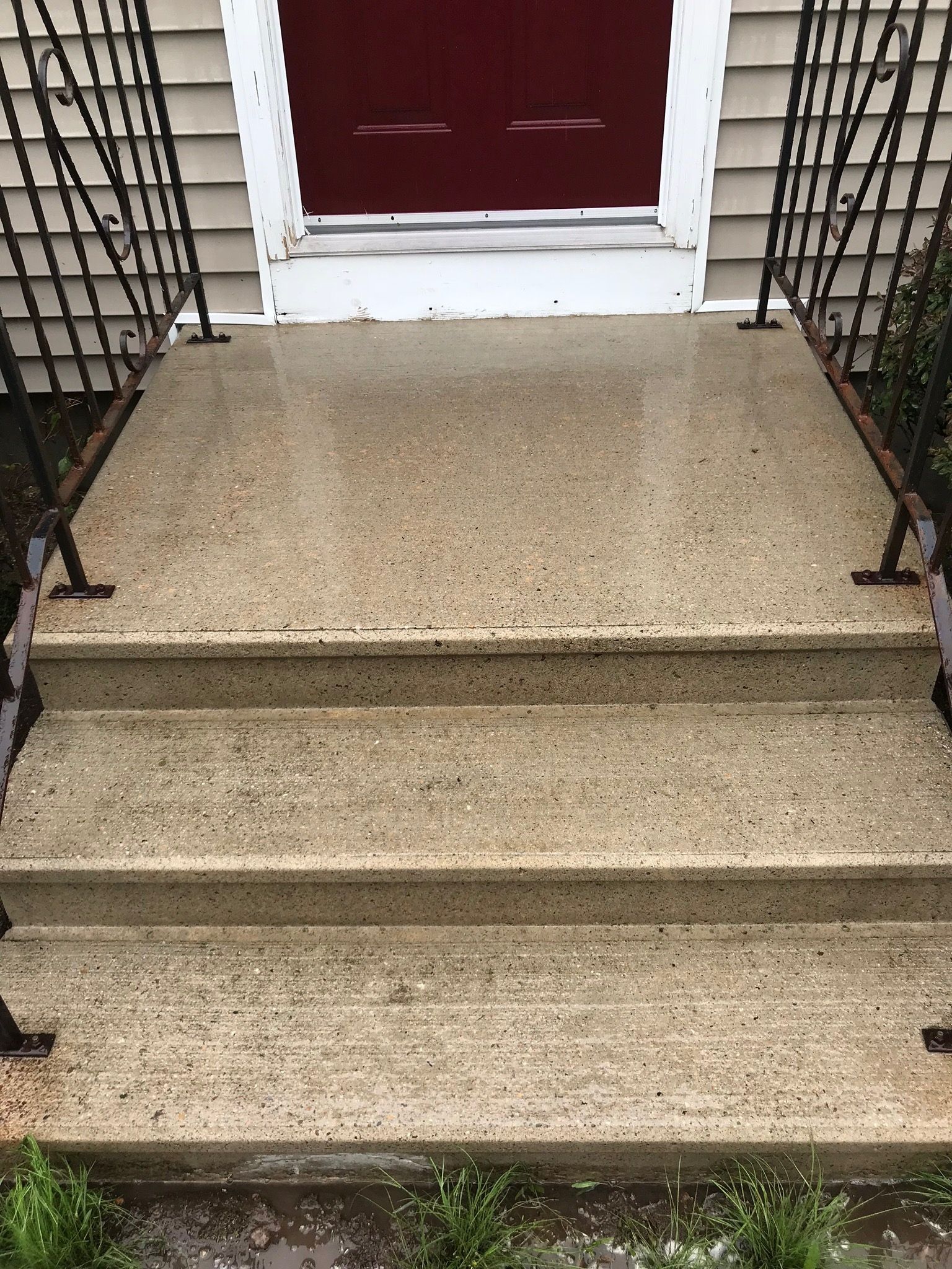A set of steps leading up to a red door of a house.
