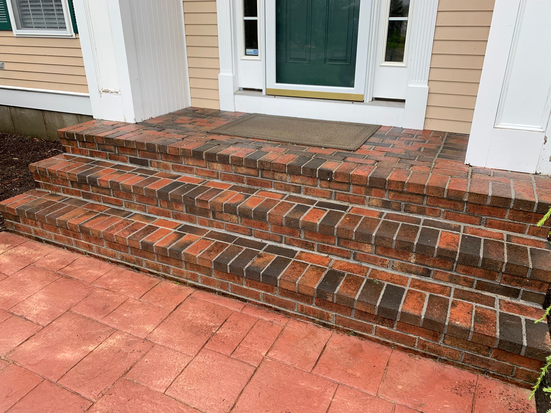 A set of brick steps leading up to the front door of a house.