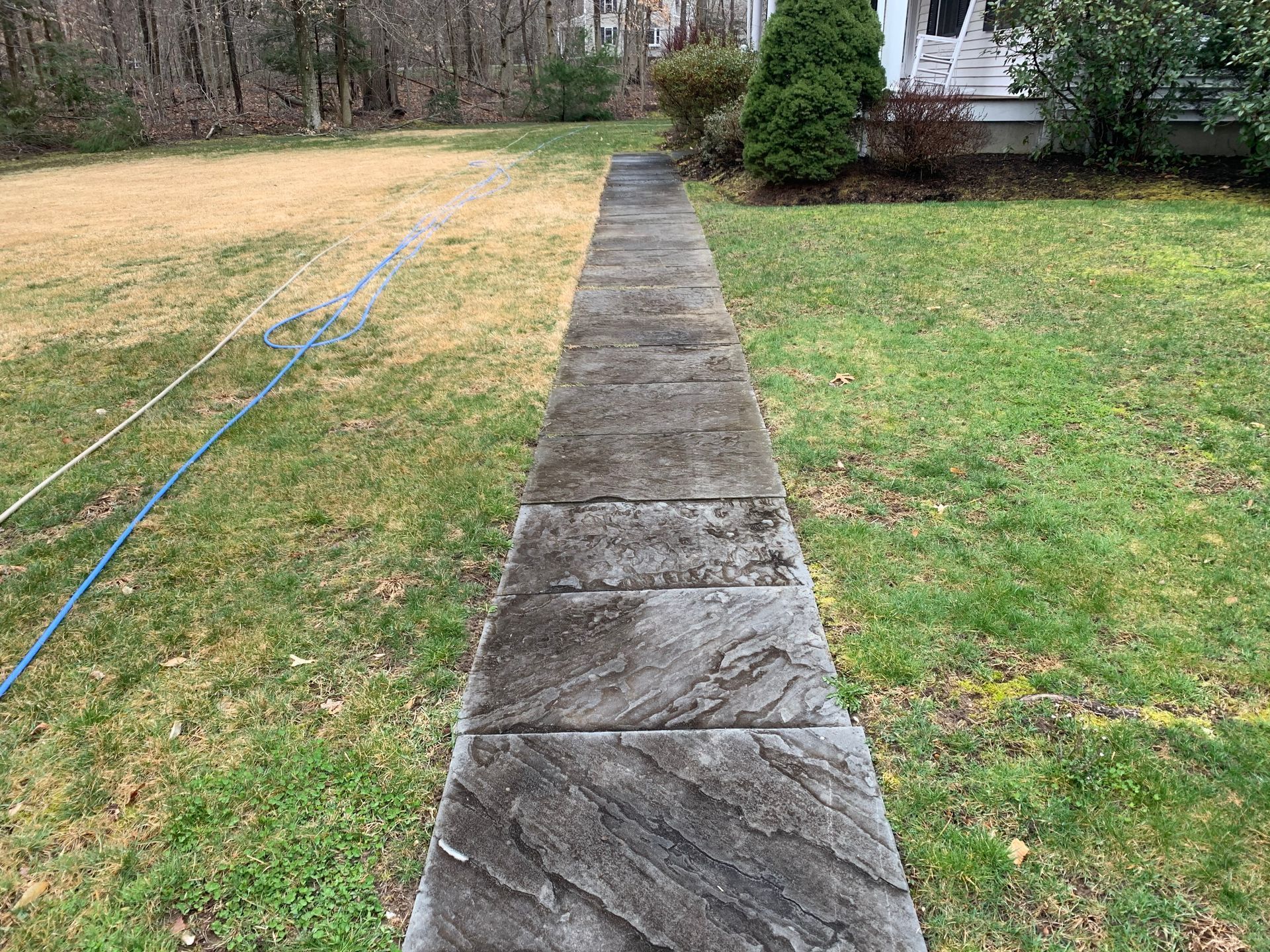 A before and after picture of a concrete walkway leading to a house.