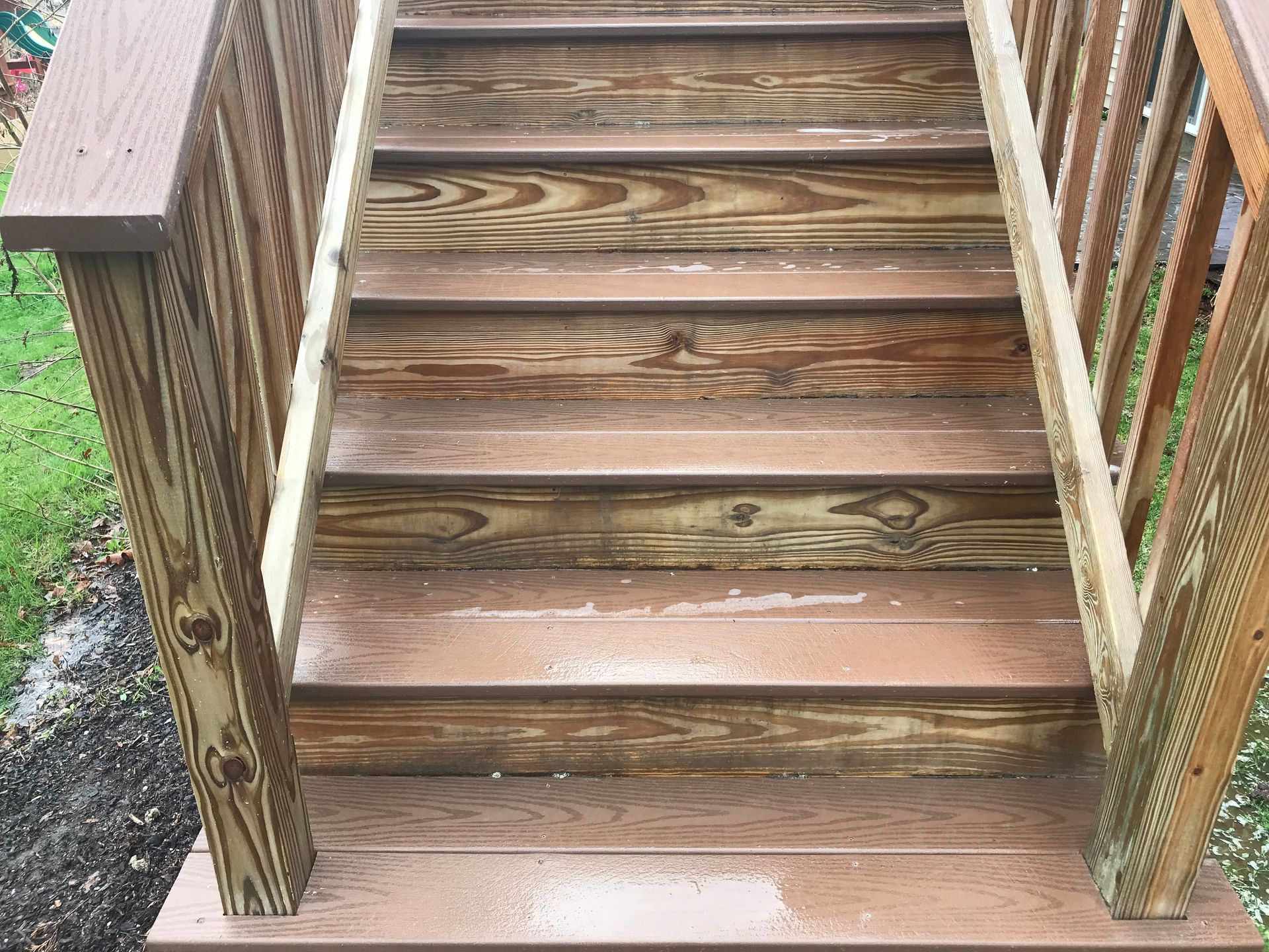 A wooden deck with stairs and a railing.