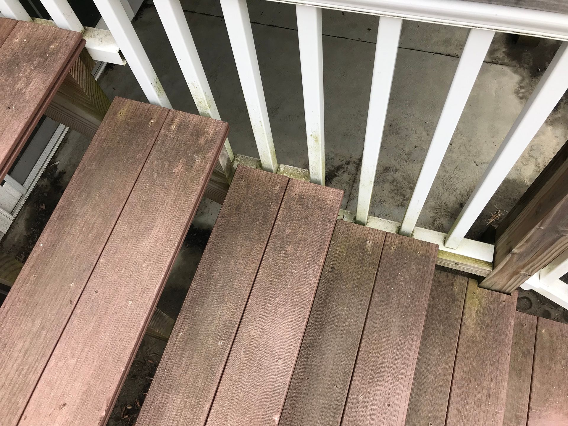 A wooden deck with stairs and a white railing.