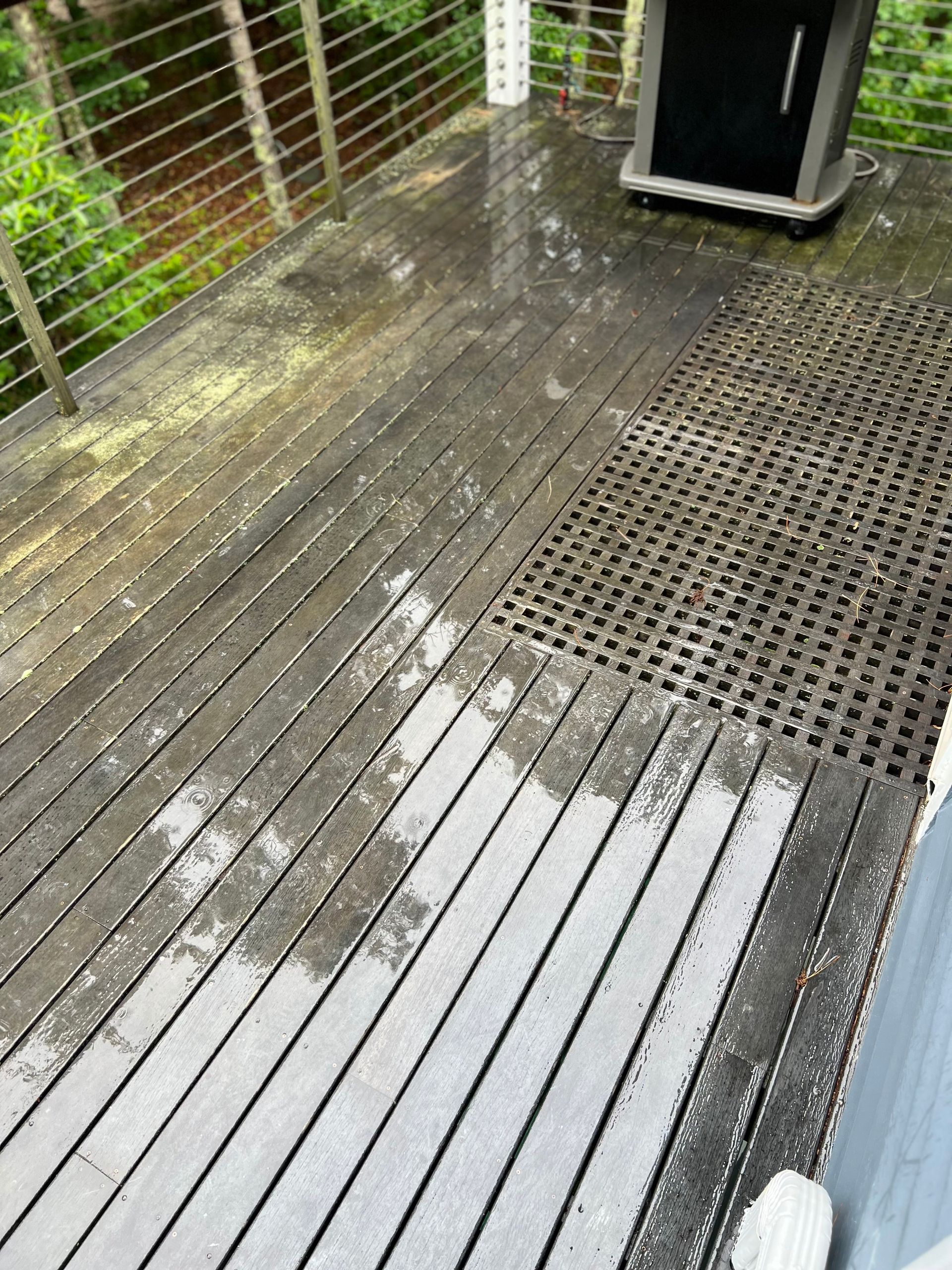 A wooden deck with a grill on top of it.