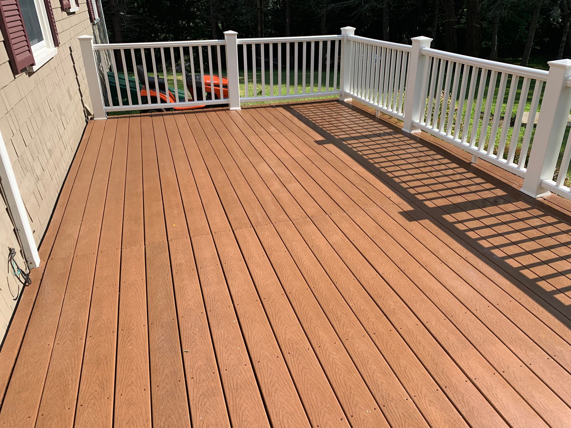 A large wooden deck with a white railing