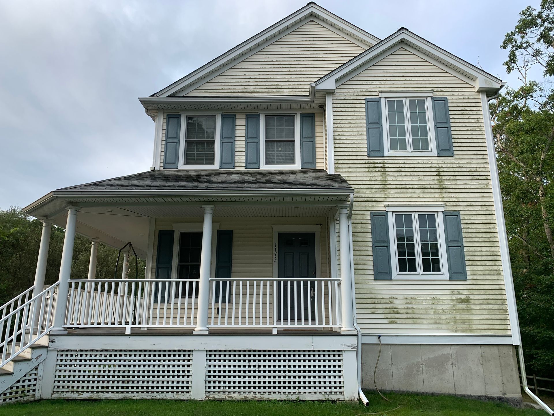 A white house with blue shutters and a porch