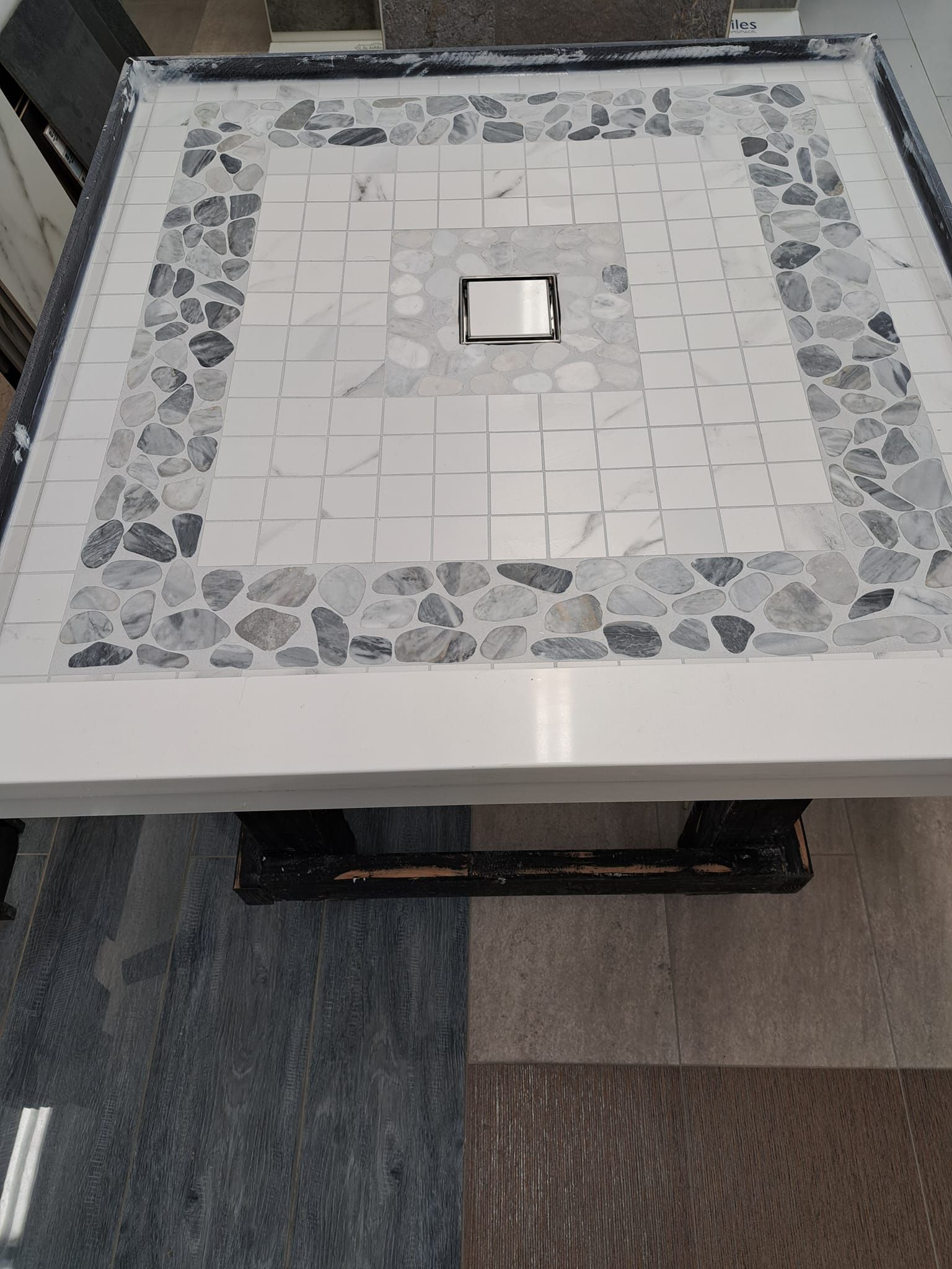 A table with a mosaic design on it is sitting on top of a carpet.