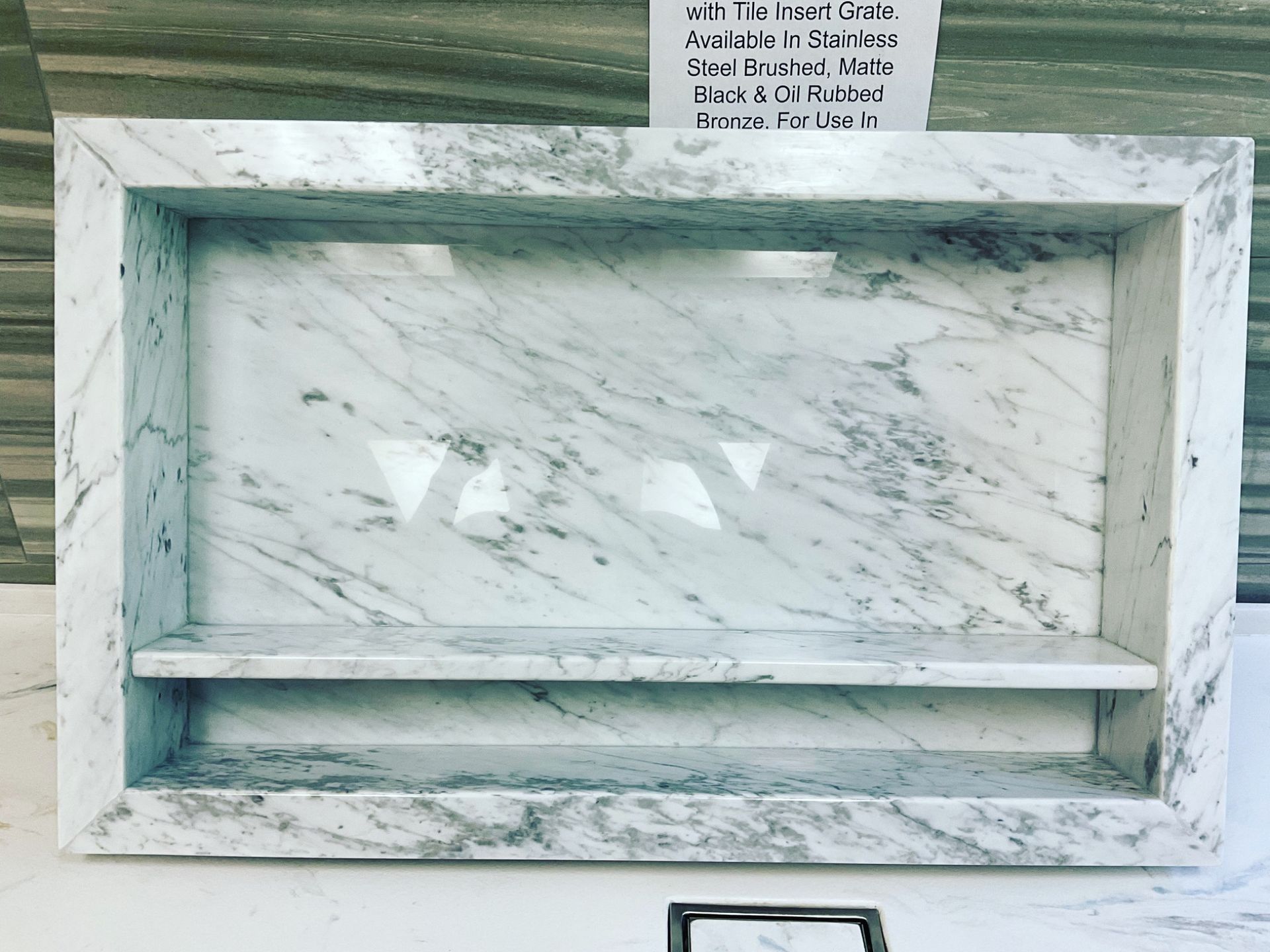 A white marble shelf with a sign on top of it.