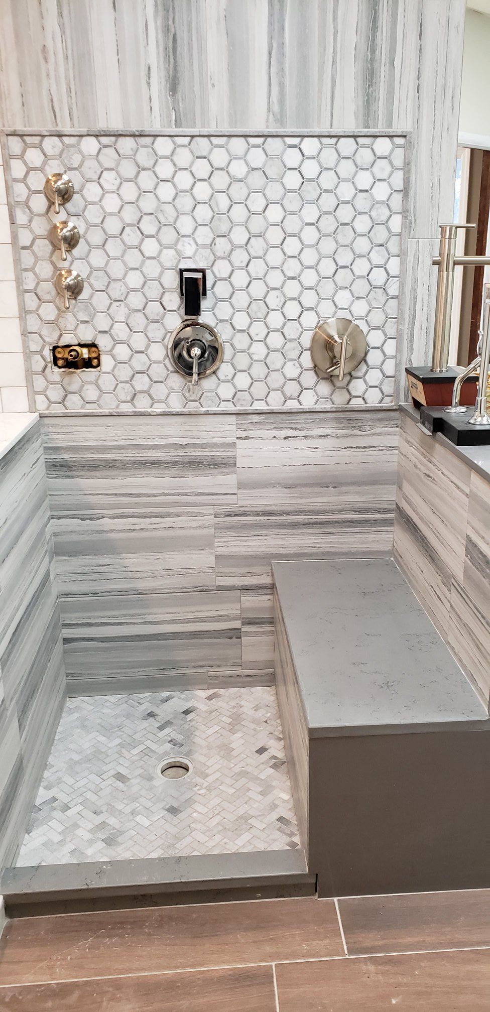 A bathroom with a walk in shower and a bench.