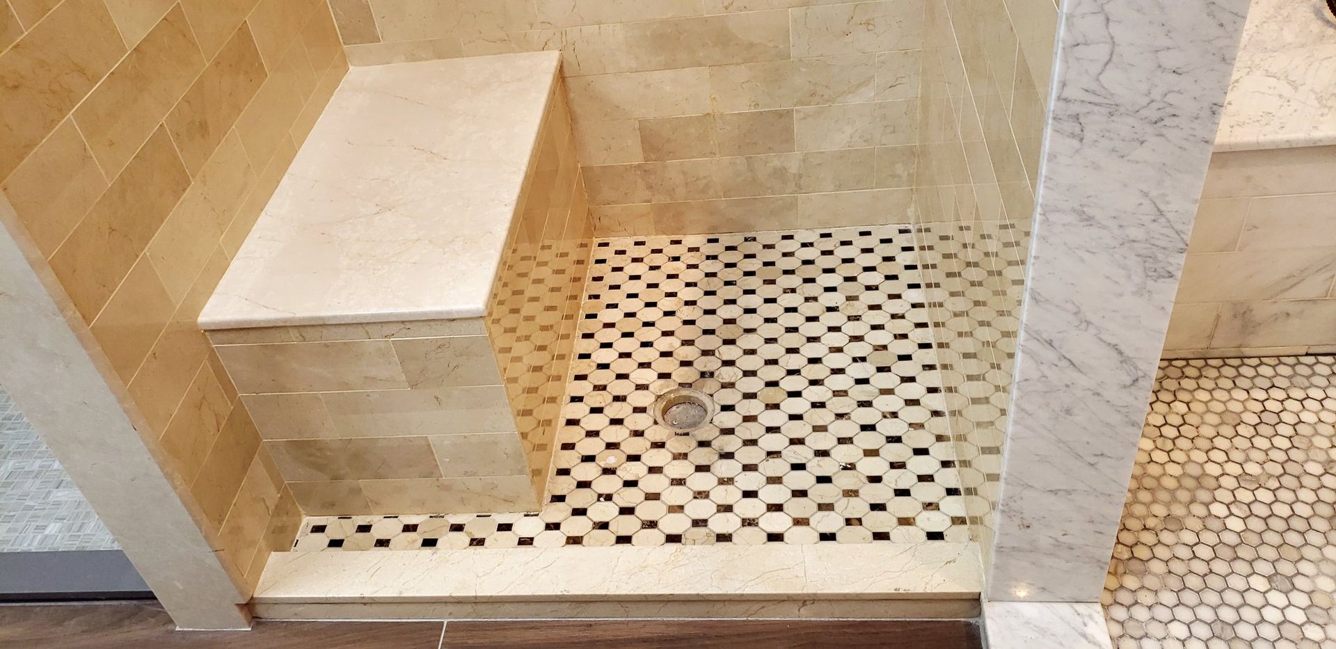 A bathroom with a walk in shower and a bench.