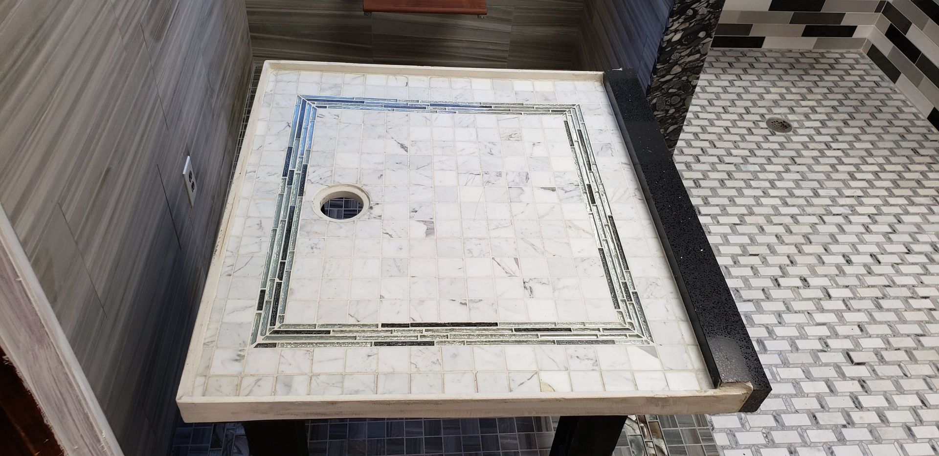 A bathroom with a tiled floor and a shower stall.
