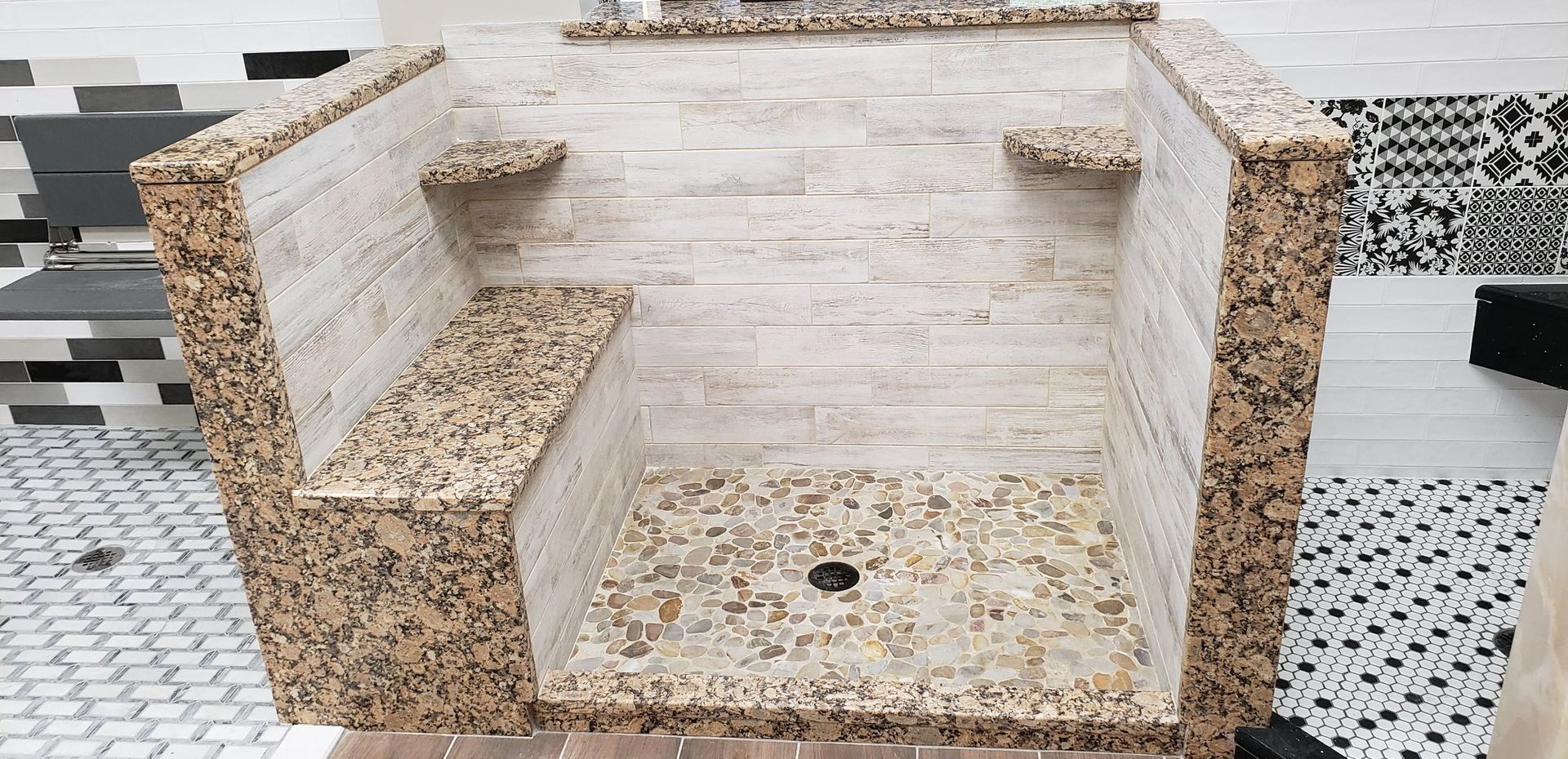 A bathroom with a walk in shower and a bench.