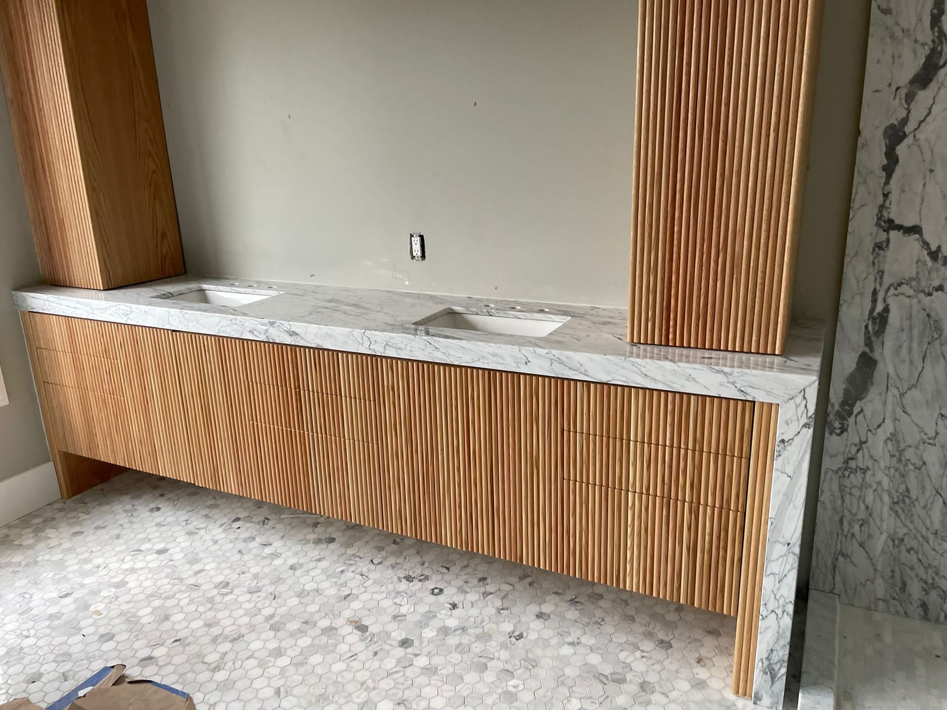 A bathroom vanity with two sinks and a marble counter top.