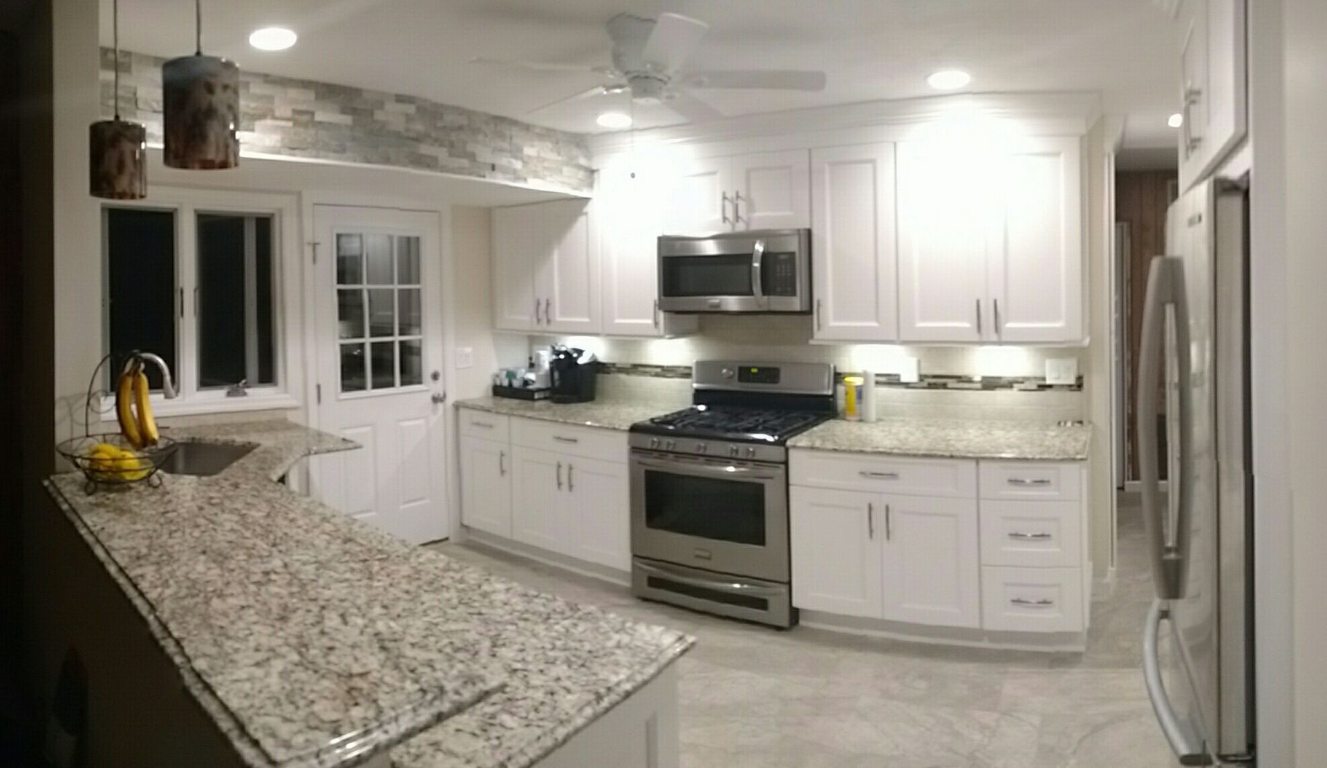 A kitchen with white cabinets and granite counter tops