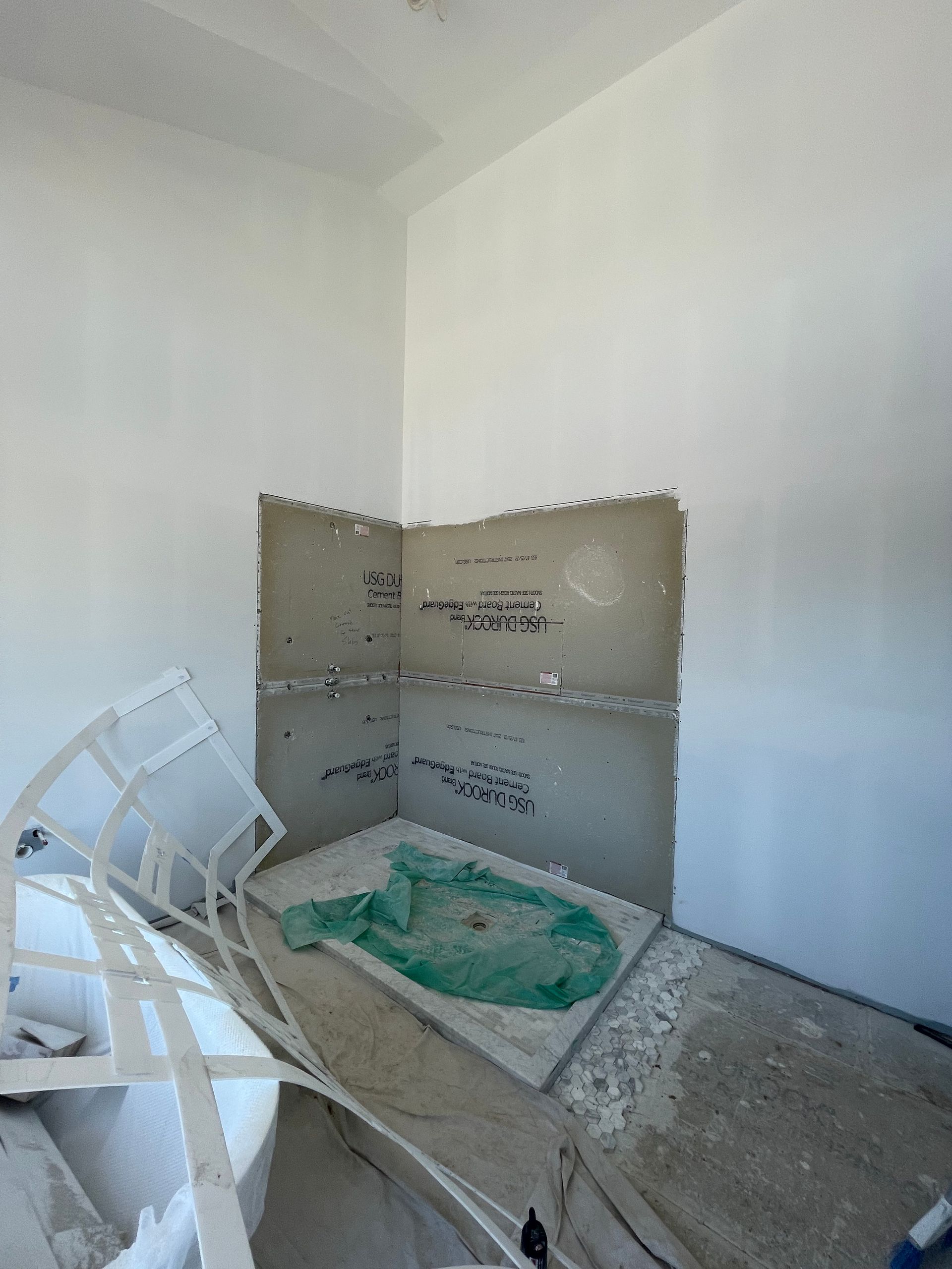 A room with white walls and a green rug on the floor