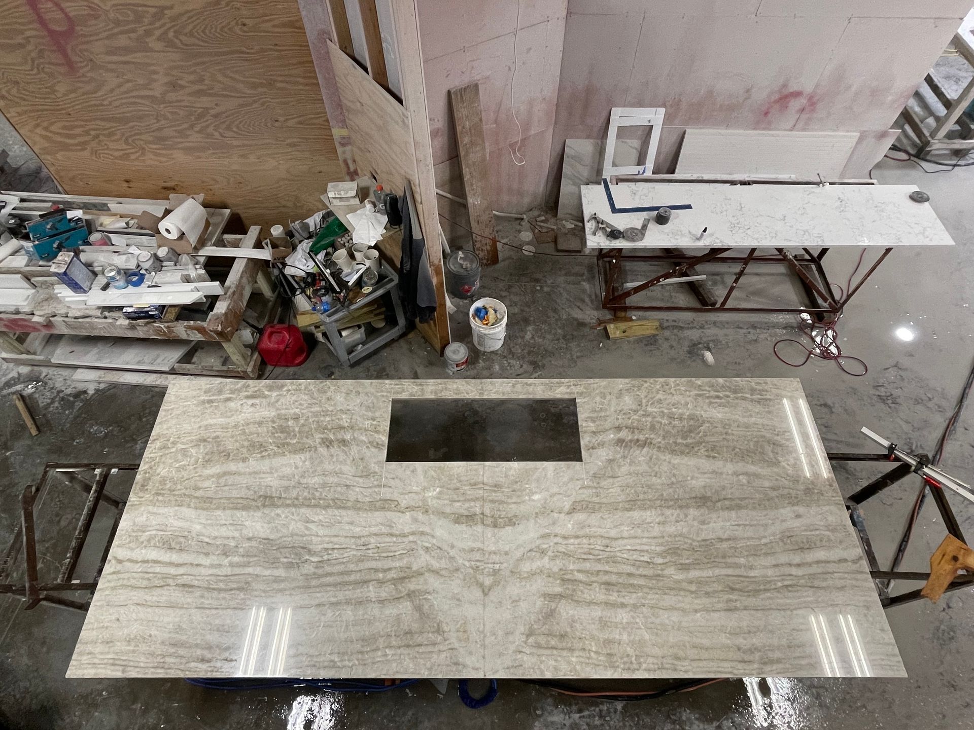 A large marble counter top with a sink in a workshop.