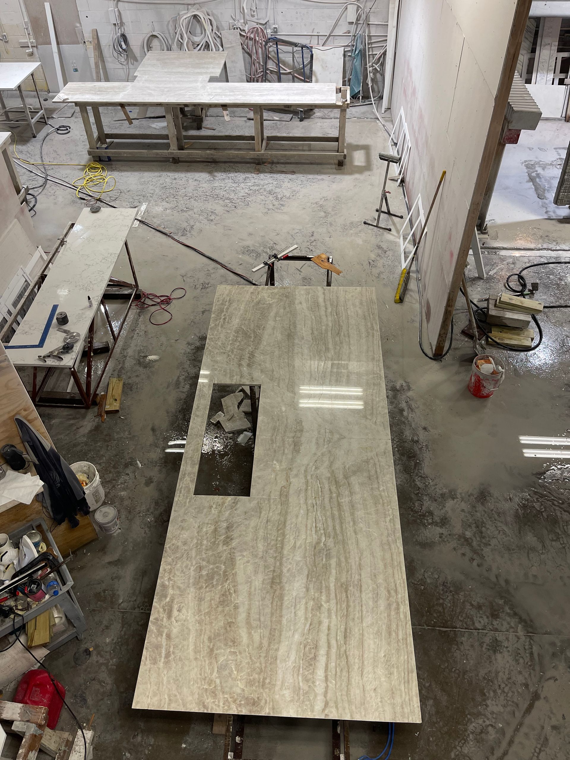 An aerial view of a marble counter top being built in a factory.