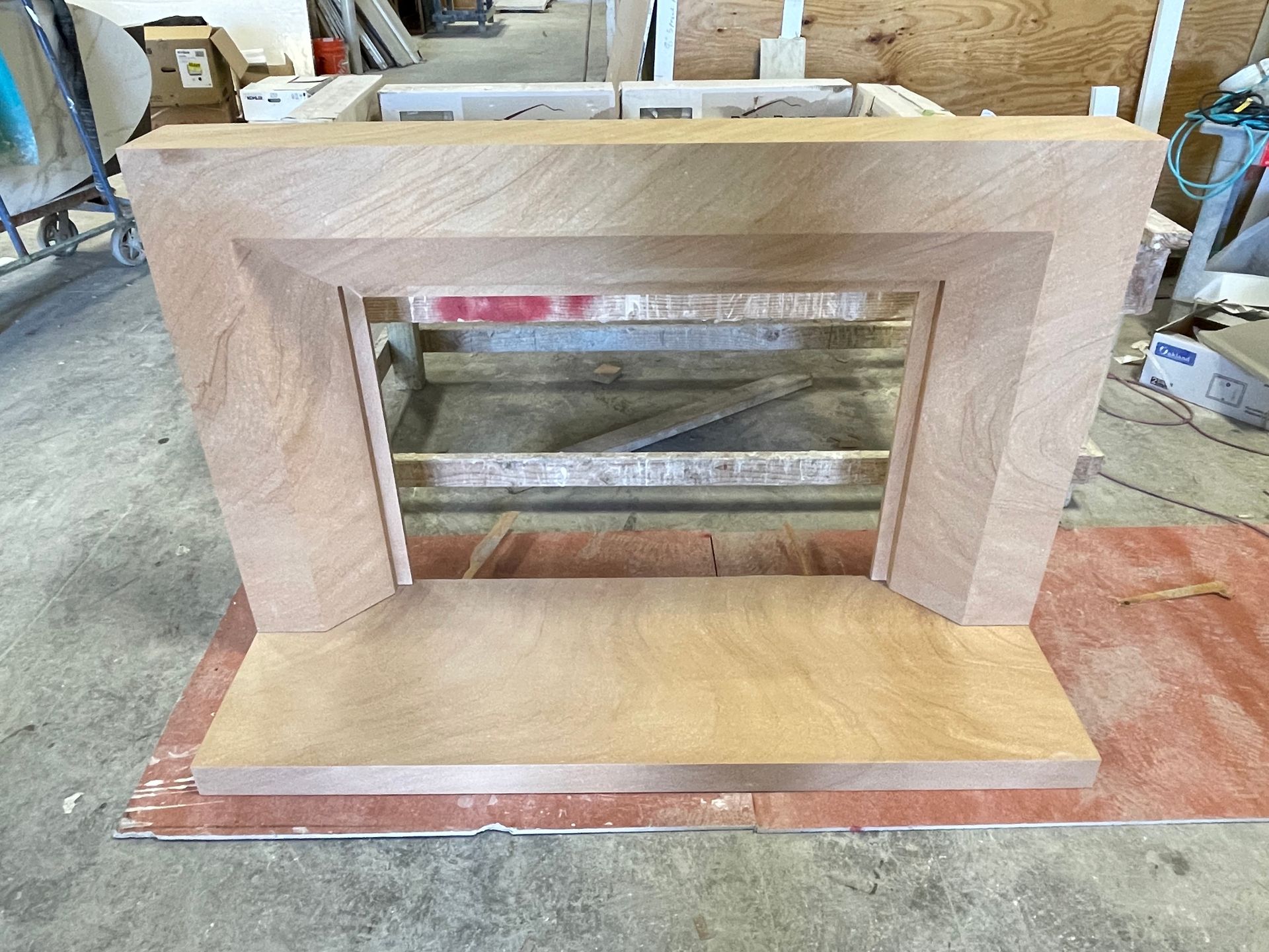 A wooden fireplace is being built in a workshop.