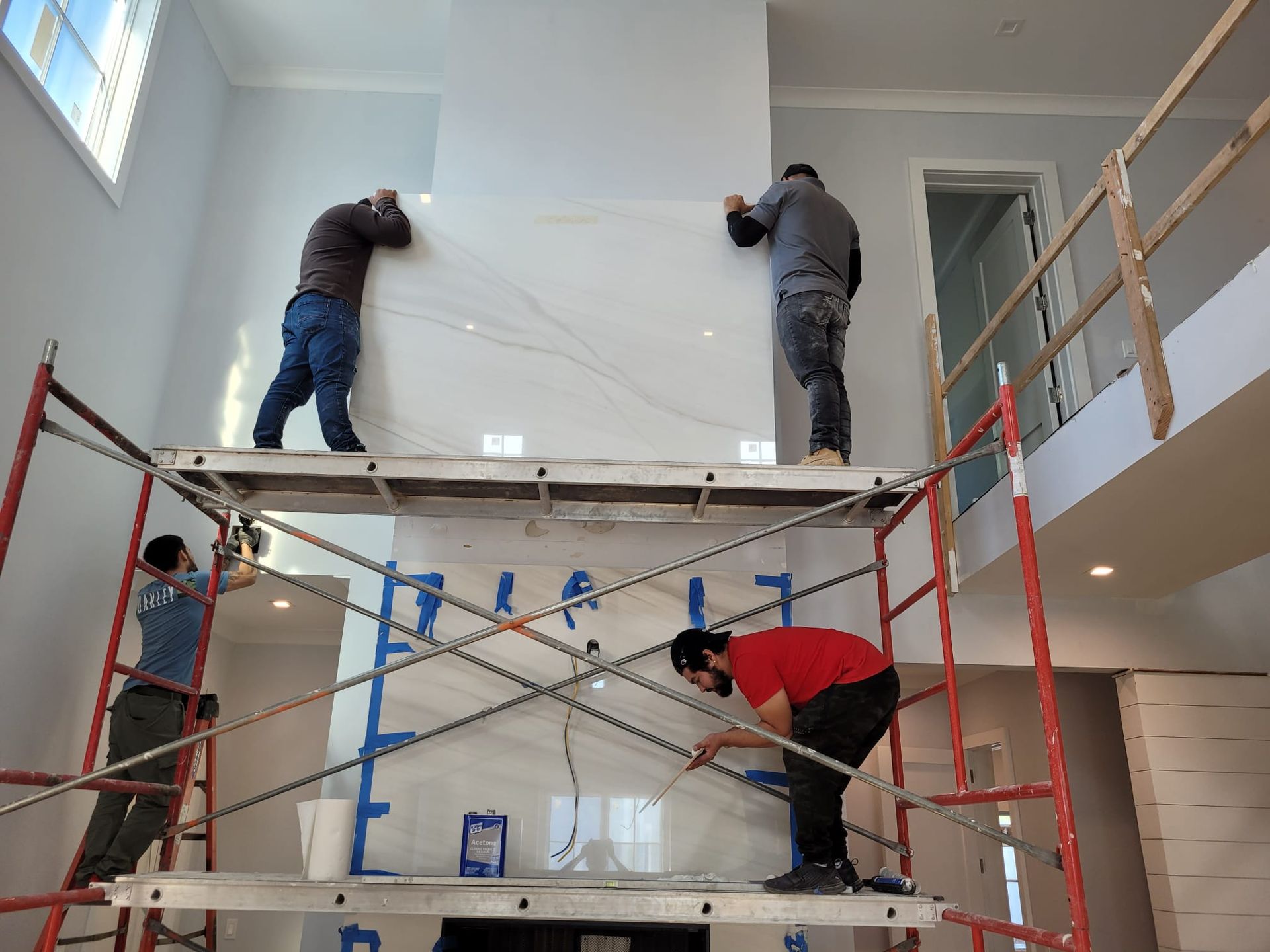 A group of men are standing on scaffolding in a room.