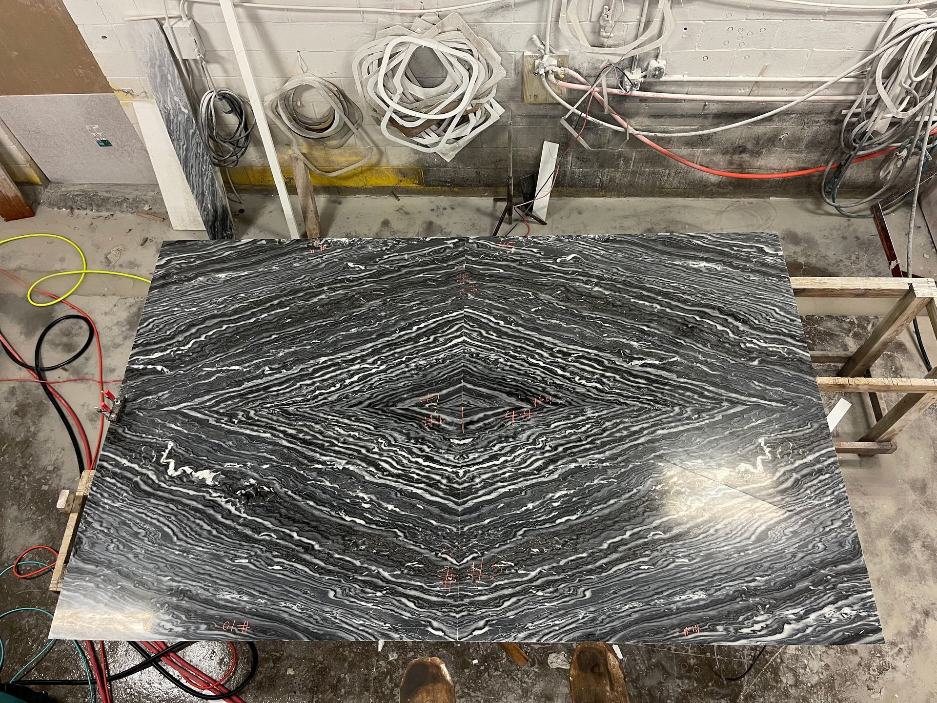 A large black and white marble slab is sitting on top of a wooden table.