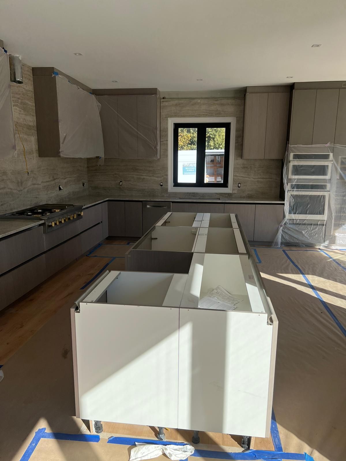 A kitchen under construction with a large island in the middle.