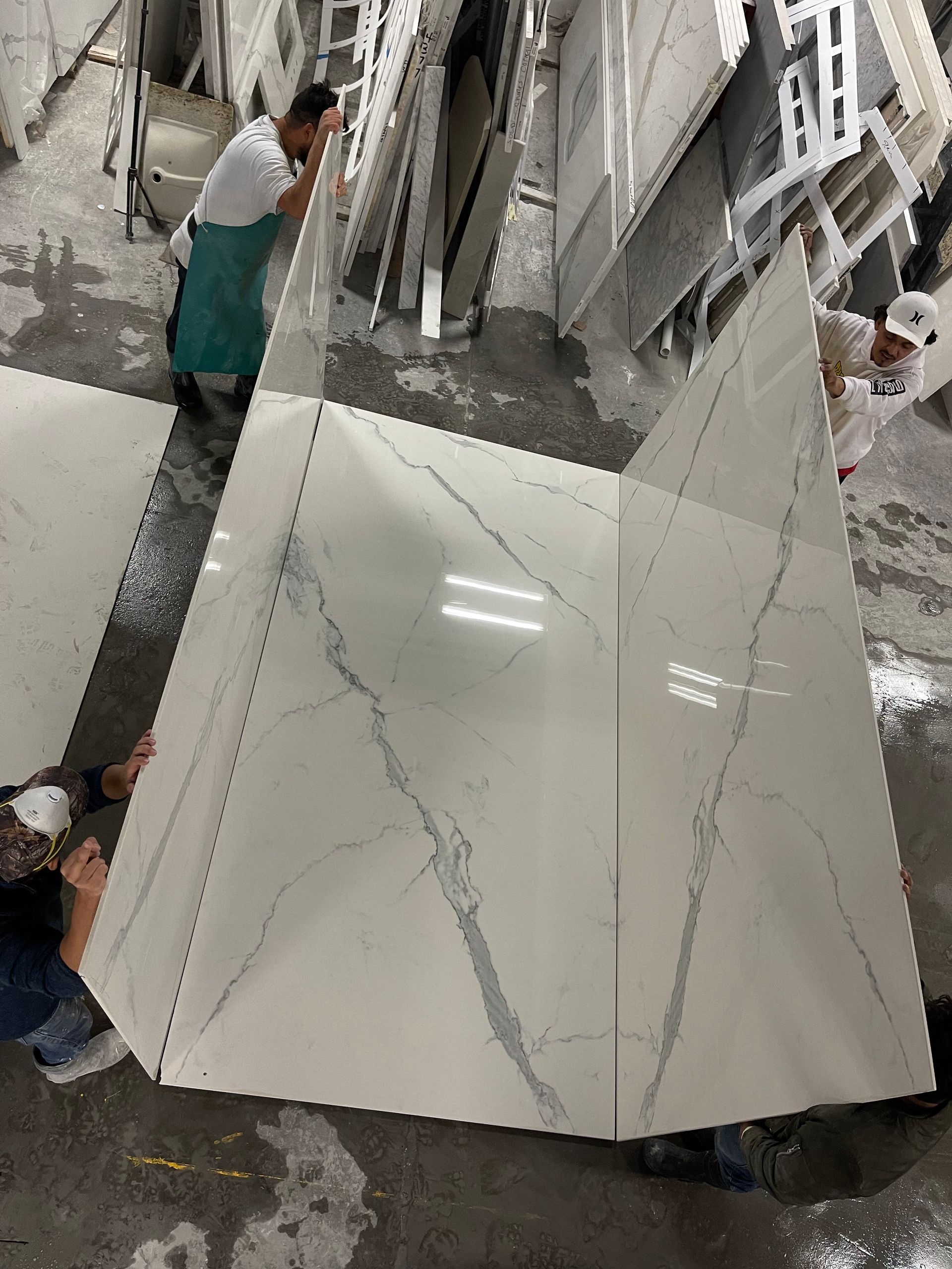 A group of people are standing around a large white tile.