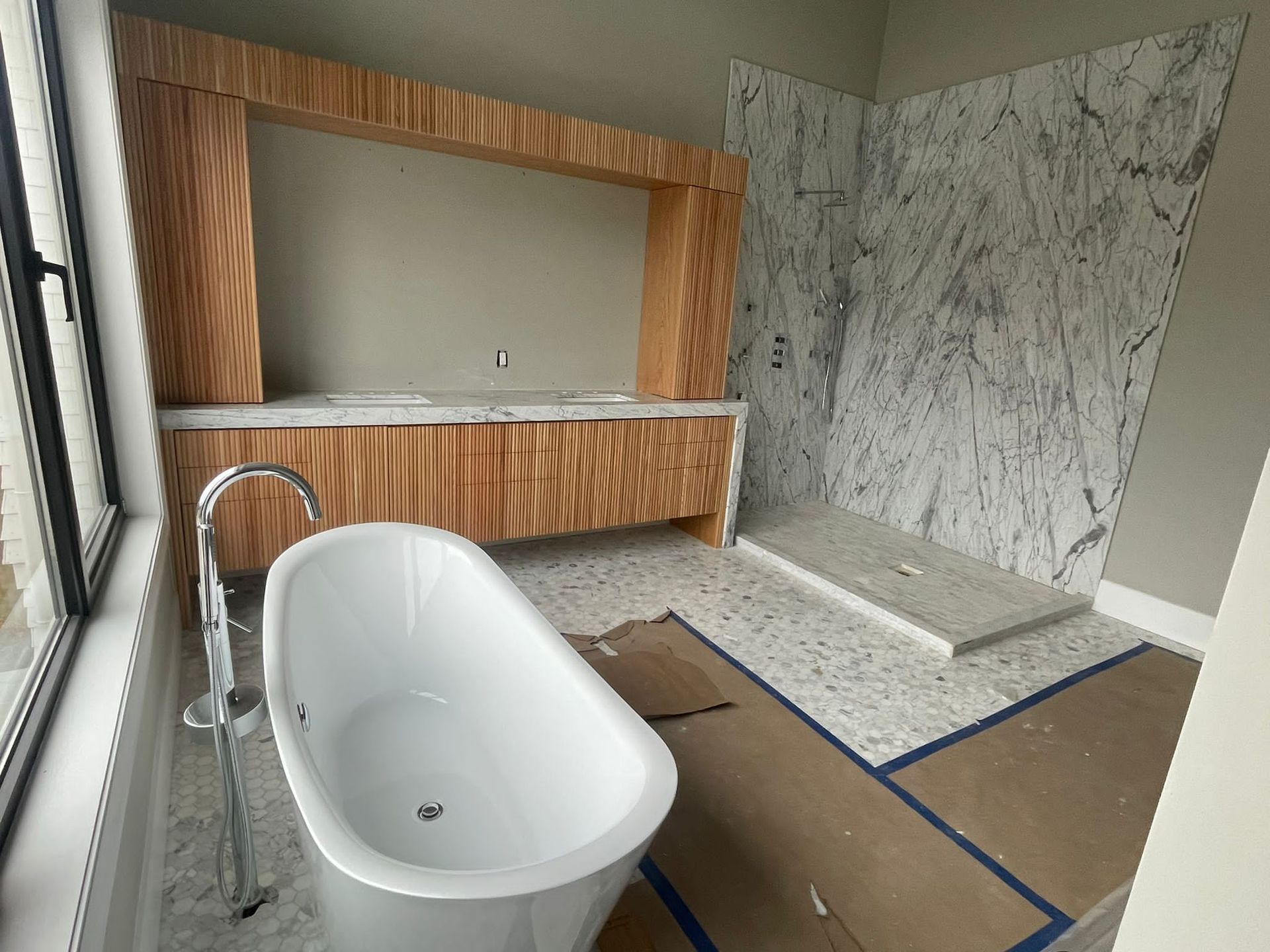 A bathroom with a bathtub, sink, and shower.