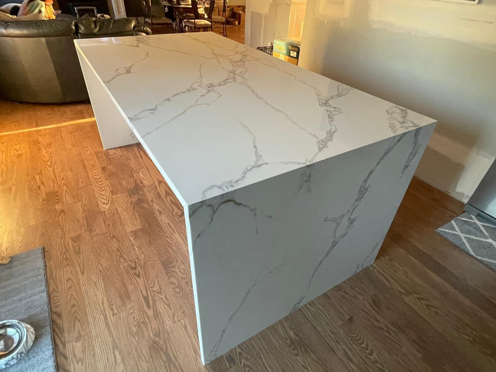 A large white marble countertop is sitting on a wooden floor in a living room.