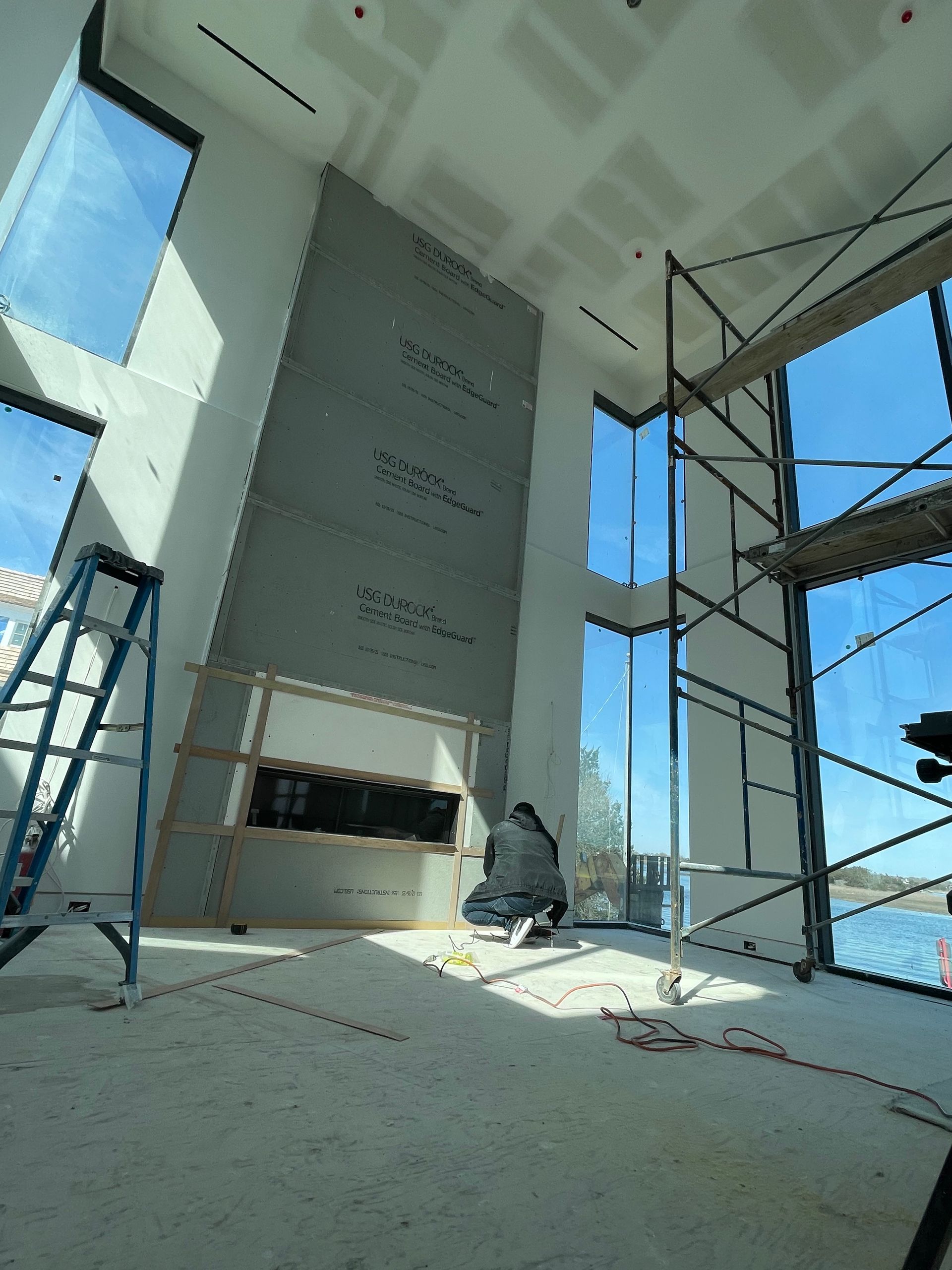 A large room with a fireplace and scaffolding in it.