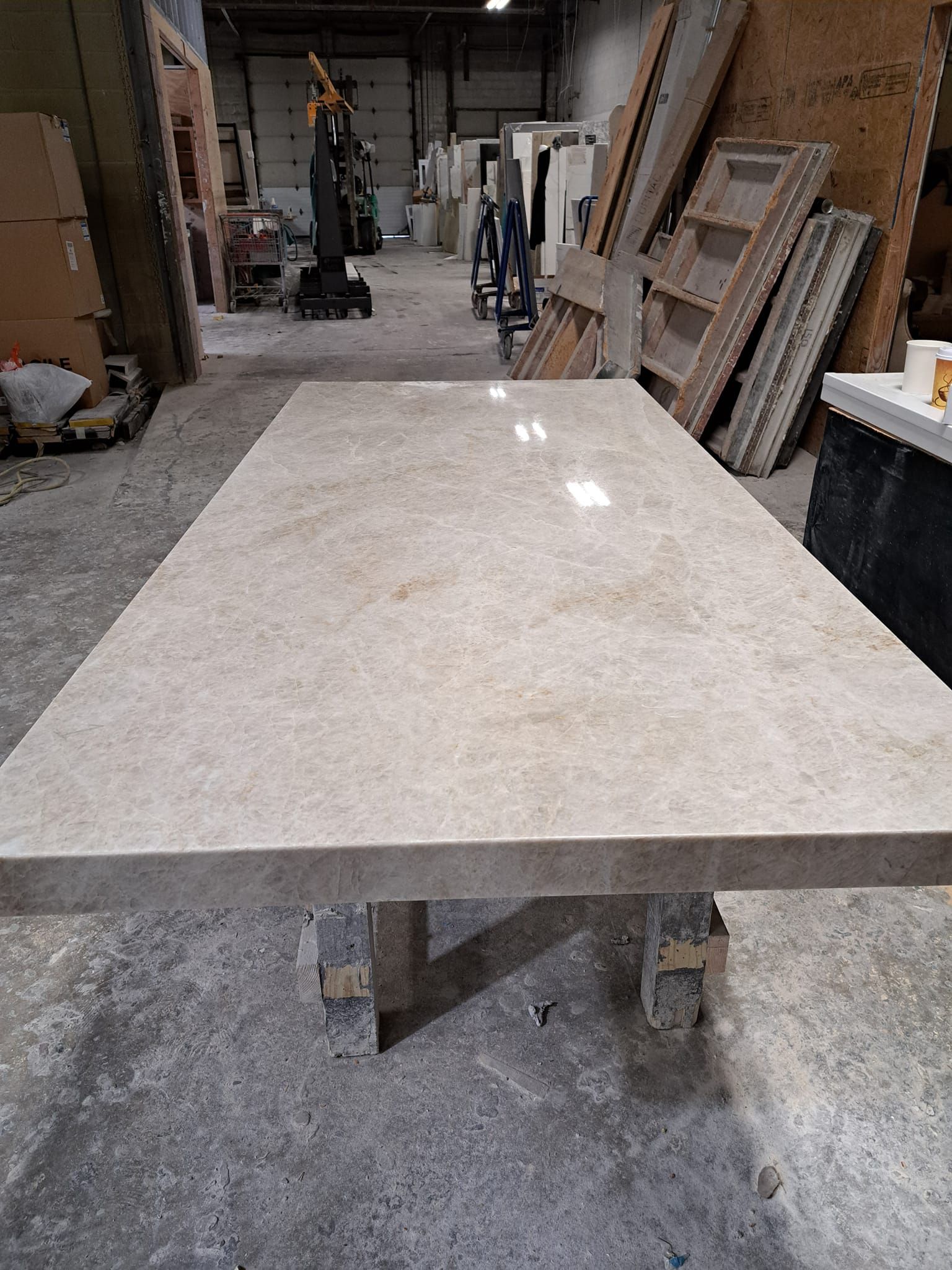 A large marble table is sitting in a warehouse.