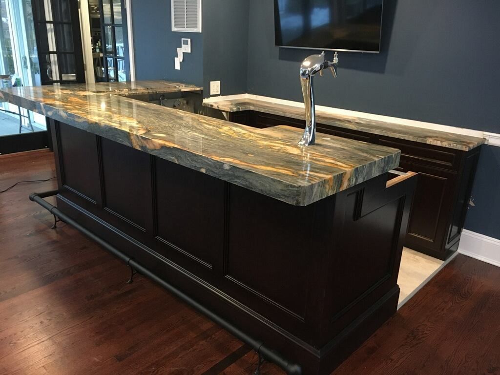 A kitchen with a bar and a television on the wall.