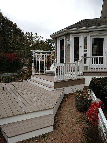 A house with a deck and stairs in front of it
