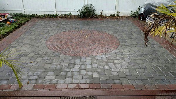 A brick patio with a circle in the middle of it