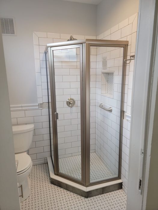 A bathroom with a toilet and a shower stall