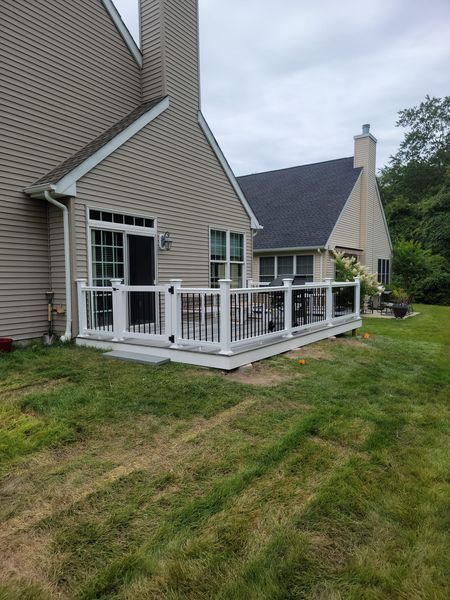 A house with a deck and a fence in front of it