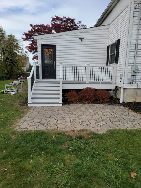 A white mobile home with a porch and stairs