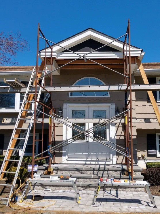 Scaffolding set up at the front door of a house for exterior renovation.