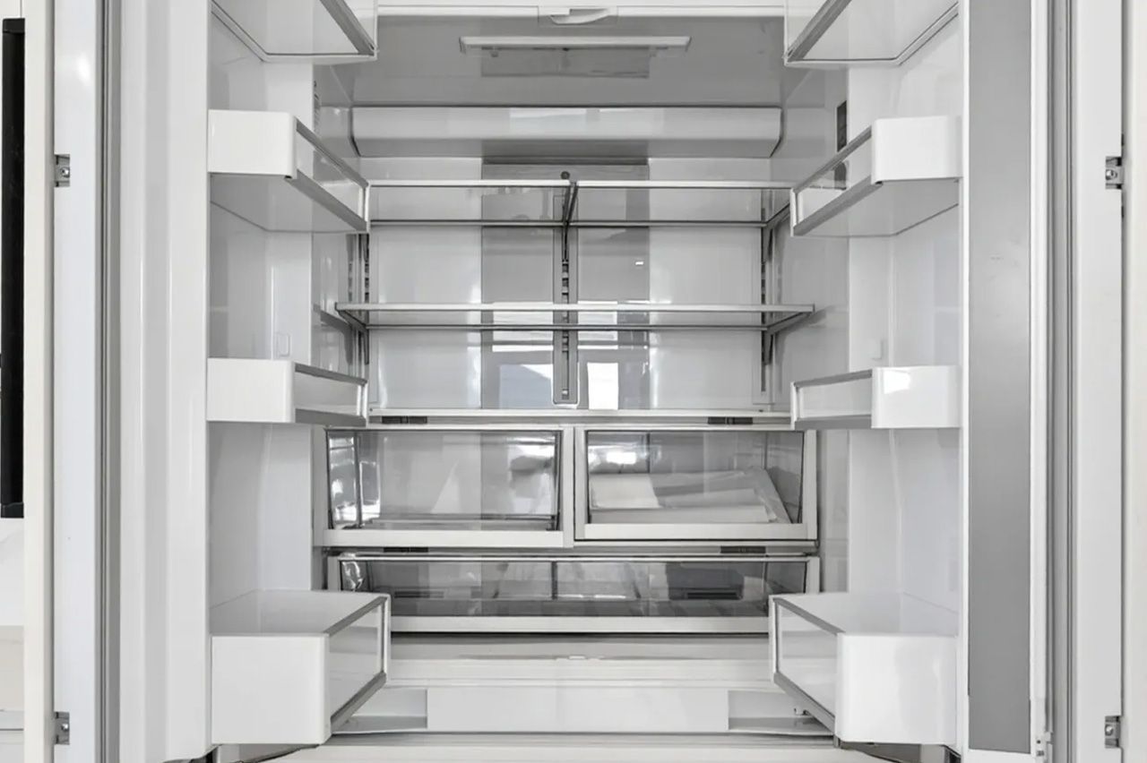 Empty stainless steel elevator interior with shelves and mirrored back wall