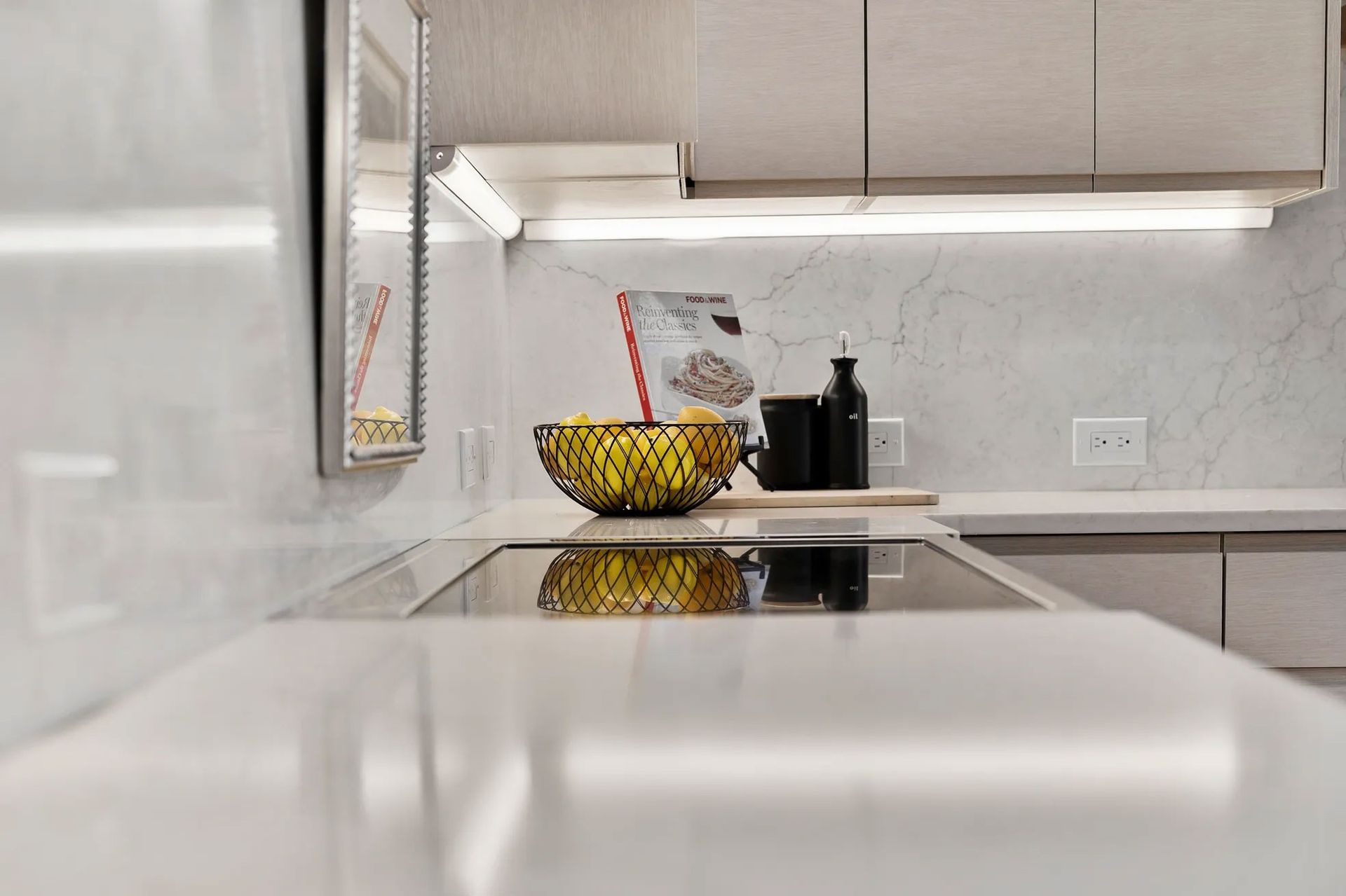 Modern kitchen countertop with a bowl of lemons and a black appliance.