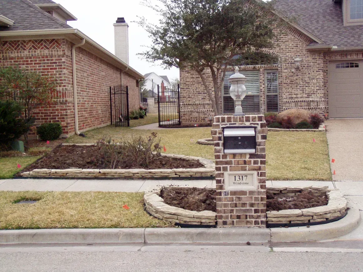 A brick mailbox in front of a brick house