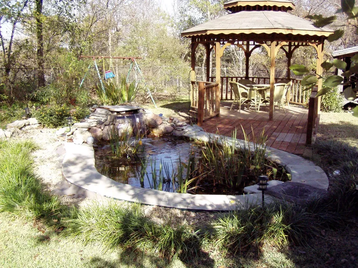 A stone walkway leading to a gazebo in a backyard