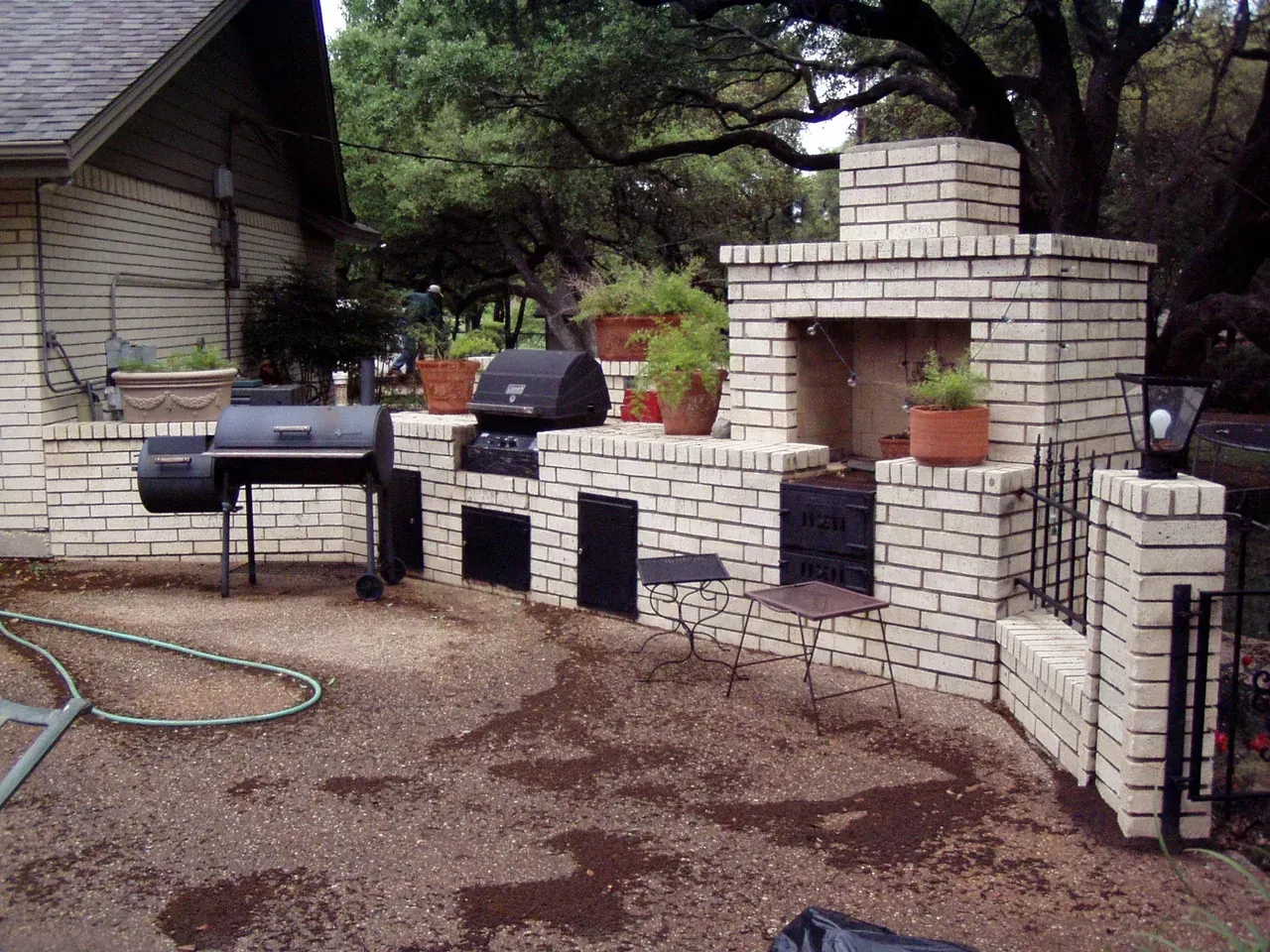 A backyard with a brick fireplace and a grill