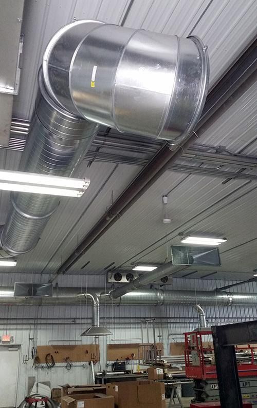 Metal HVAC ducting and ventilation pipes on a warehouse ceiling