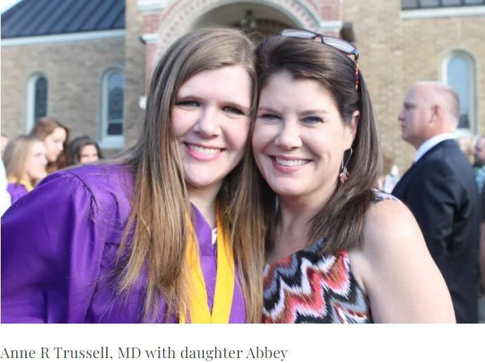 Anne R. Trussell, MD, and her daughter Abbey smile at the camera in front of a building.